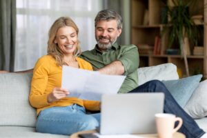 Happy middle-aged couple reviewing their home's electricity usage and needs.
