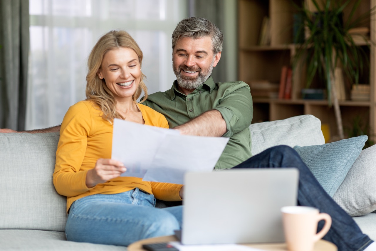 Happy middle-aged couple reviewing their home's electricity usage and needs.
